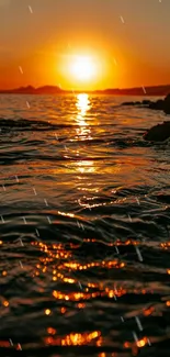 Orange sunset ocean view wallpaper with rippling water.