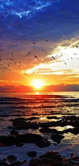 A breathtaking sunset over the ocean with birds in the sky.