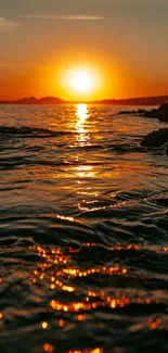 Golden sunset over a calm ocean with gentle reflections.