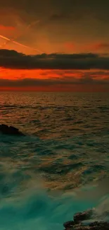 Sunset view of the ocean with waves crashing against rocks under a cloudy sky.