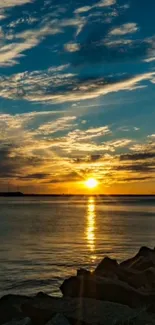 Beautiful sunset over calm ocean with glowing sky and clouds.