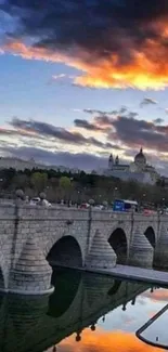 Sunset reflecting over a stone bridge and river with vibrant colors.