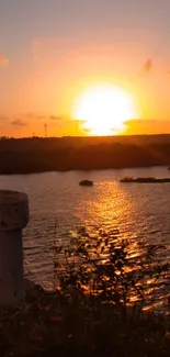 A beautiful sunset over a calm lake with orange and golden hues.