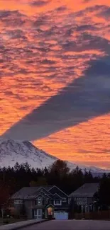 Vibrant sunset casting shadows over a snow-capped mountain.