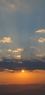 Serene sunset over mountains with dramatic clouds and golden sky.