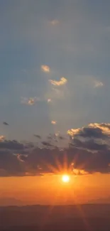 Beautiful sunset over mountains with an orange and blue sky.