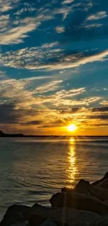 Beautiful sunset over an ocean with rocks in the foreground.