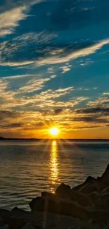 A stunning sunset over the calm ocean with a vibrant blue sky and golden reflections.