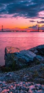 Beautiful mobile wallpaper showcasing a sunset over a bridge with vibrant pink hues.