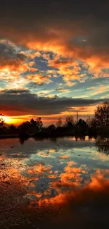 Vibrant sunset reflection over a calm lake with orange and blue sky.