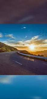 Sunset over winding road with vibrant sky.