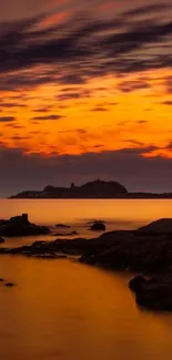 Sunset over a rocky seascape with vibrant orange hues.