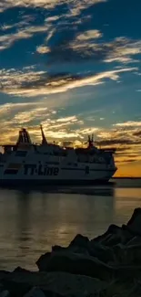 Silhouette of a ship at sunset with a navy blue sky and calm waters.