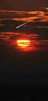 Vibrant sunset with dark clouds and orange sun, creating a stunning sky display.