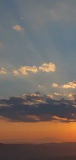 Stunning sunset sky with orange and blue hues and scattered clouds.