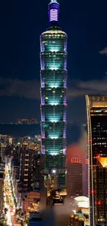 Taipei 101 towering over cityscape at night.