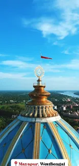 Aerial view of Mayapur temple dome against a blue sky.