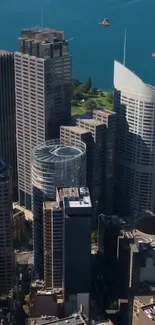 Aerial cityscape view with skyscrapers and blue water background.