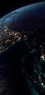 Satellite view of Earth at night, highlighting illuminated cityscapes.