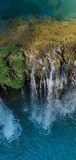 Aerial view of a stunning waterfall with blue waters and lush greenery.