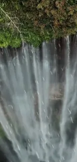 Aerial view of a picturesque waterfall cascading down surrounded by lush green foliage.