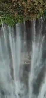 Aerial view of a waterfall with lush green surroundings.