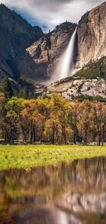 Majestic waterfall in mountain landscape with autumn colors and calm reflection.