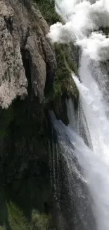 Breathtaking waterfall cascading over rugged cliff with lush greenery.