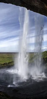 Breathtaking view of a waterfall and lush landscape under a bright sky.