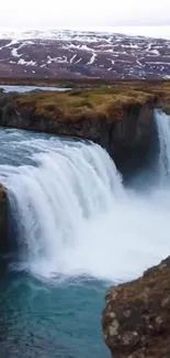 Majestic waterfall cascading over rugged cliffs in a serene natural landscape.