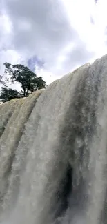 Majestic waterfall flowing under a blue sky.