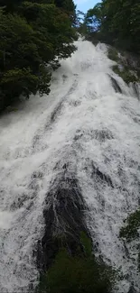 Stunning waterfall with lush greenery and serene flowing water.