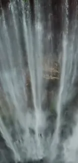 Majestic waterfall flowing down rocky cliffs, creating a tranquil scene.