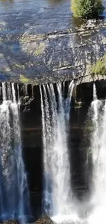 Serene view of cascading waterfall with lush greenery.