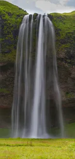 Stunning mobile wallpaper of a waterfall cascading down lush greenery.