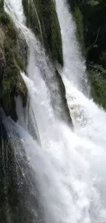 Cascading waterfall amidst lush greenery on mobile wallpaper.