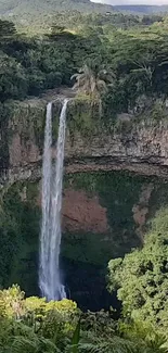 Breathtaking waterfall amidst lush greenery and rocky cliffs.