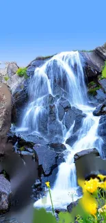 Beautiful waterfall with blue sky and rocky landscape, perfect for nature wallpaper.