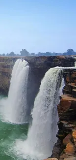 Majestic waterfall with rugged cliffs and serene water flow in nature.