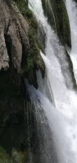 Beautiful waterfall cascading down rocks with lush green surroundings.