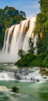 Stunning waterfall with lush green trees, perfect for mobile wallpaper.