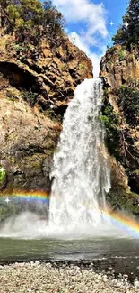 Waterfall with rainbow amidst rocky cliffs and vibrant natural scenery.