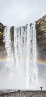 Mobile wallpaper of a majestic waterfall with a rainbow.