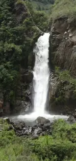 Lush green landscape with a waterfall cascading down rocky cliffs.