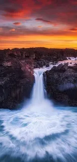 Waterfall at sunset with vibrant red sky and dramatic landscape.