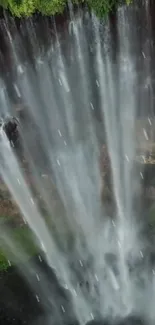 Vertical view of a stunning waterfall cascading down amidst lush greenery.