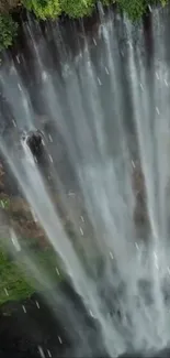 Breathtaking vertical view of a cascading waterfall with lush greenery.