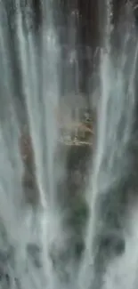 Vertical waterfall with cascading streams over rocky surface.