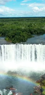 Breathtaking waterfall with rainbow over lush greenery.