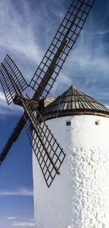 A rustic windmill set against a serene blue sky, perfect for a mobile wallpaper.